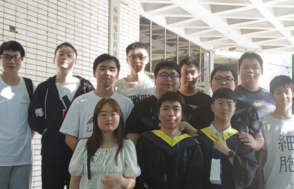 2022 年,穿学位服的队员与伙伴在校园廊下合影