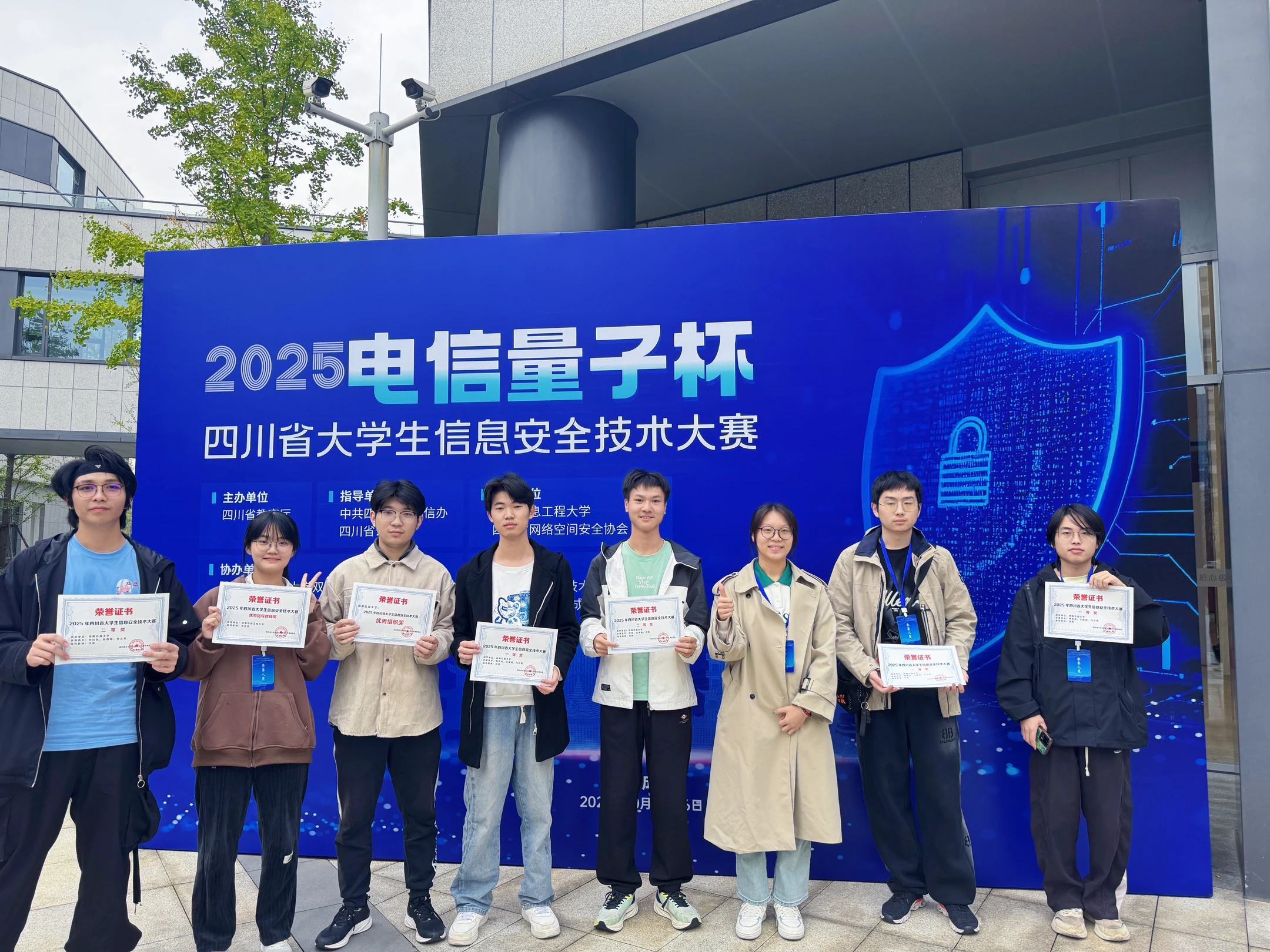 八位队员手持证书,在2025电信量子杯四川省大学生信息安全技术大赛背景板前合影