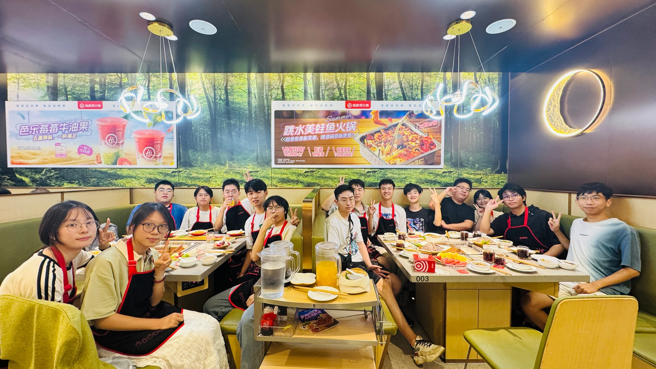 队员们围坐在餐桌旁,一起举手合影